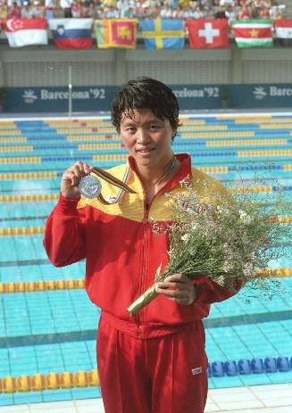 This picture shows Coach Wang holding her Olympic metal
