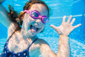 A girl is making a funny face under water