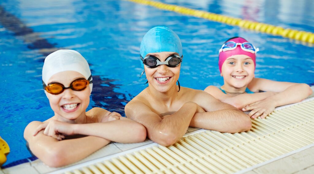 This picture shows three kids happily smiles in a swimming pool