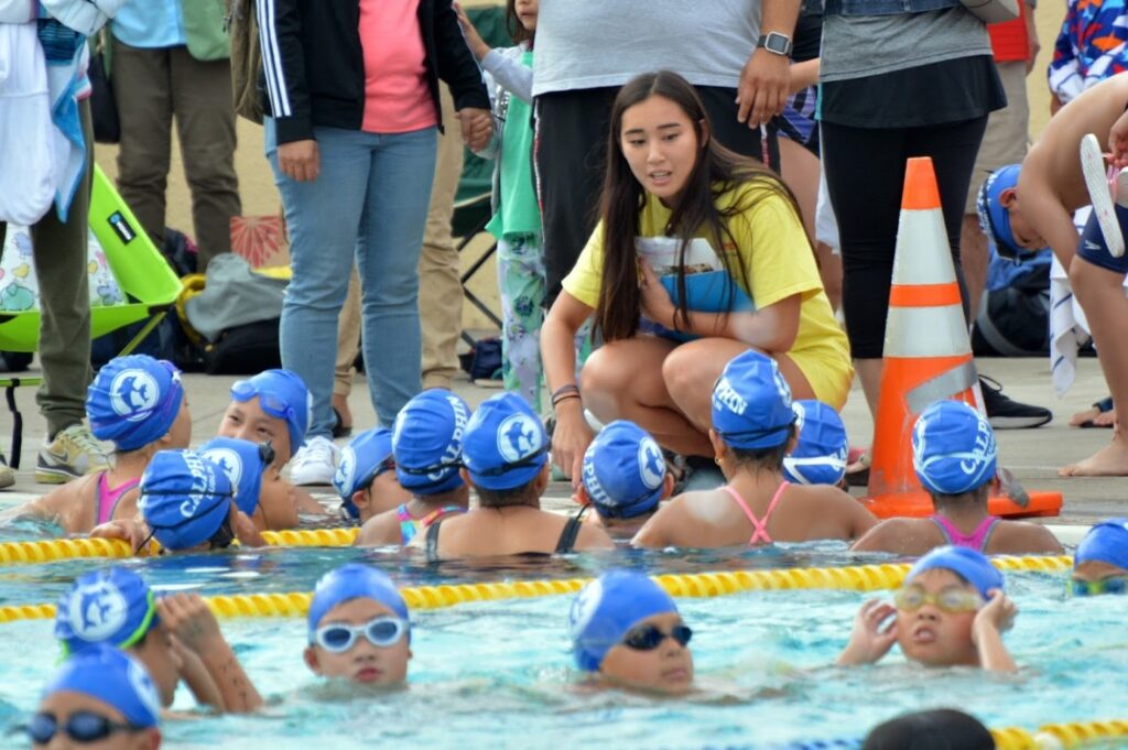 This picture shows a female coach and her students in a swim meet